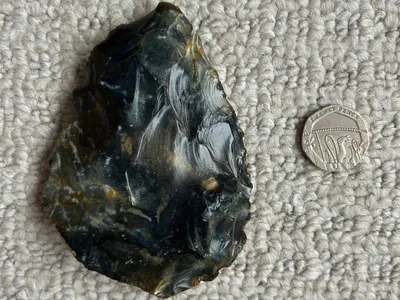 The hand ax, seen here beside a 20-pence coin, is between 40,000 and 60,000 years old.