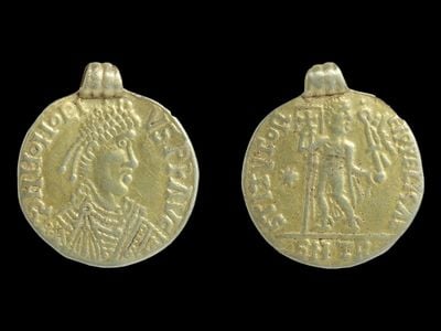 The coin features the bust of Honorius on one side. The other side depicts a person holding a&nbsp;banner or flag with a cross on it.
