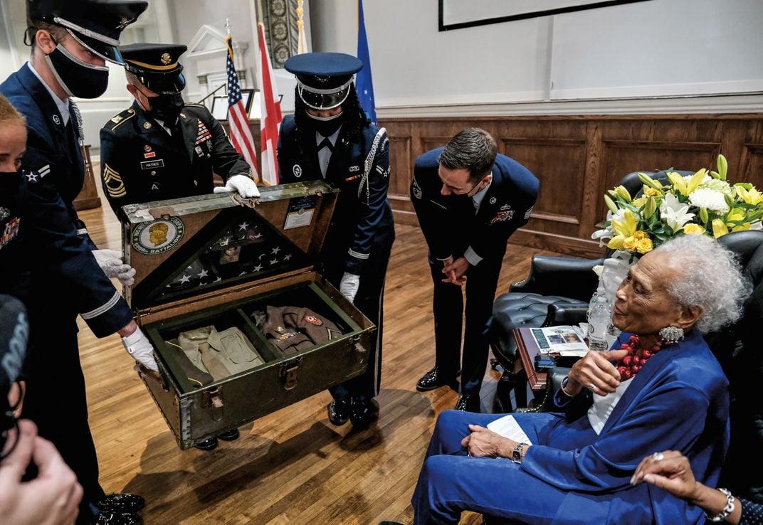 A Black woman sitting receives military honors